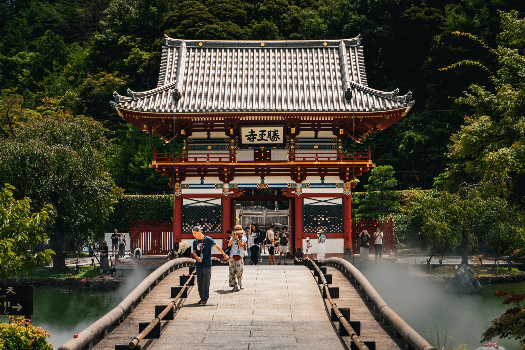 The gate of Katsuoji Temple seen across a stone bridge, Osaka.