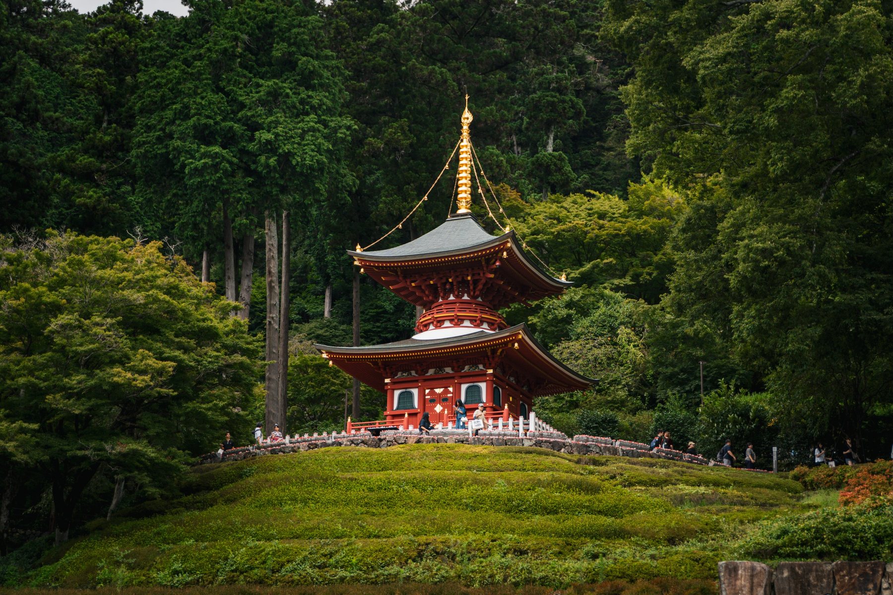 A red and gold pagoda on a mossy hill at Katsuoji Temple, Osaka.