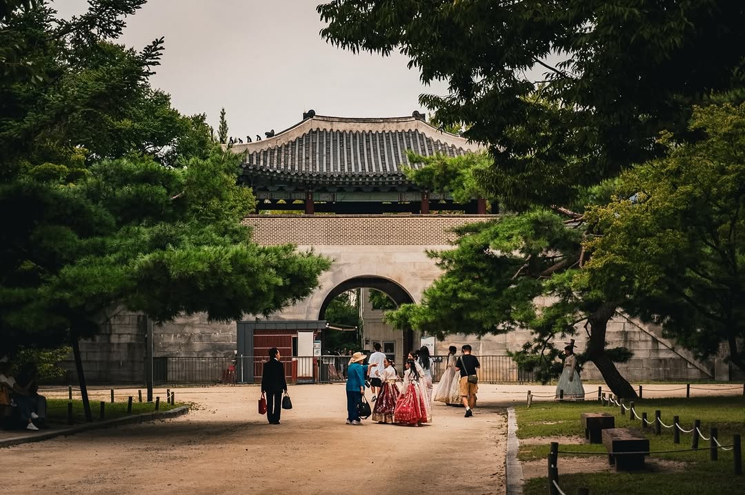 A tiled gate at Gyeongbokgung, with visitors in the courtyard, Seoul.